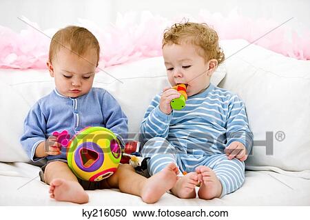 Two babies playing with toys View Large Photo Image Stock Image - Two babies playing with toys. Fotosearch