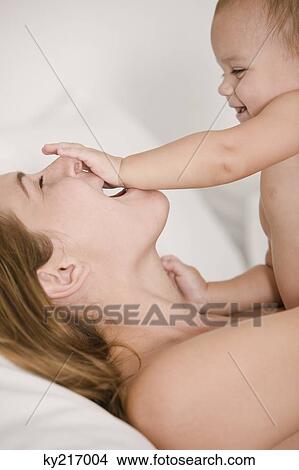Picture - Close-up of a woman playing with her daughter. Fotosearch