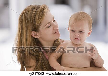 Woman carrying her crying daughter View Large Photo Image Stock Image - Woman carrying her crying daughter. Fotosearch