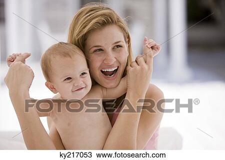 Stock Image - Woman holding her daughter and laughing. Fotosearch