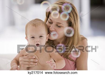 Woman holding her daughter View Large Photo Image Picture - Woman holding her daughter. Fotosearch