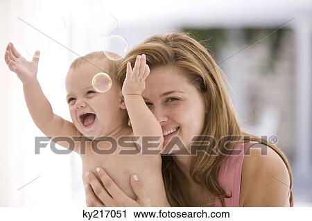 Woman hugging her playful daughter View Large Photo Image Stock Image - Woman hugging her playful daughter. Fotosearch