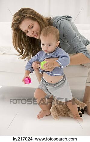 Woman supporting her daughter learning to walk View Large Photo Image Picture - Woman supporting her daughter learning to walk. Fotosearch