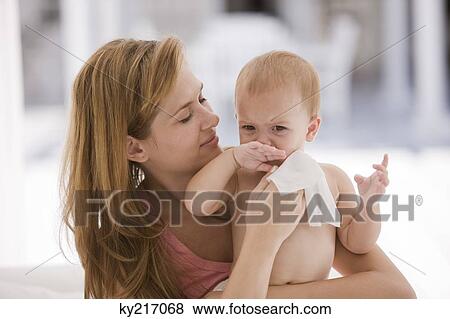 Woman wiping her daughter's blowing nose View Large Photo Image Stock Photo - Woman wiping her daughter's blowing nose. Fotosearch