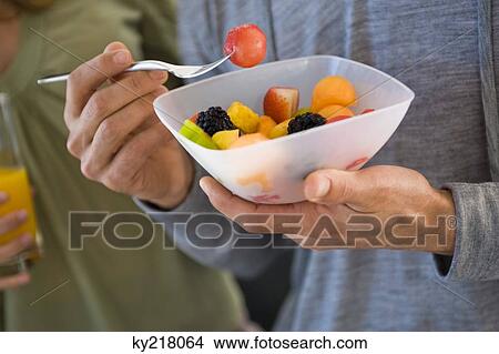 Close-up of a man eating fruit salad View Large Photo Image Picture - Close-up of a man eating fruit salad. Fotosearch