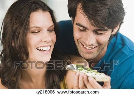 Stock Photograph - Couple eating bread and smiling. Fotosearch