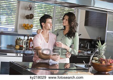 Stock Photo - Couple having breakfast in the kitchen. Fotosearch