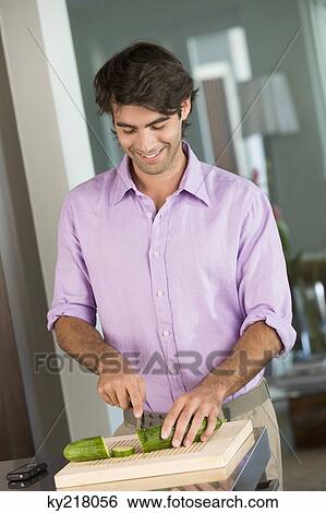 Man cutting a cucumber View Large Photo Image Stock Photograph - Man cutting a cucumber. Fotosearch