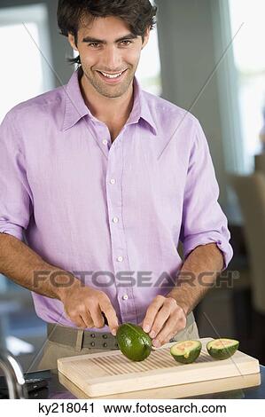 Man cutting avocado and smiling View Large Photo Image Stock Image - Man cutting avocado and smiling. Fotosearch