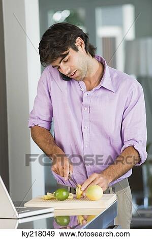 Man cutting lime slices and talking on a mobile phone View Large Photo Image Stock Photo - Man cutting lime slices and talking on a mobile phone. Fotosearch