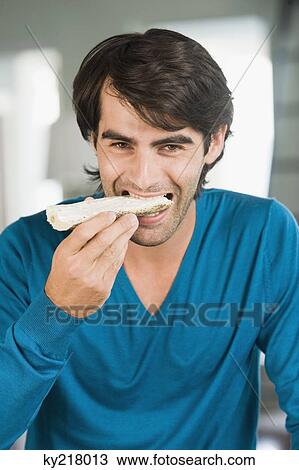 Man eating a bread View Large Photo Image Stock Image - Man eating a bread. Fotosearch