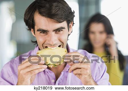 Man eating a pineapple slice View Large Photo Image Stock Photo - Man eating a pineapple slice. Fotosearch