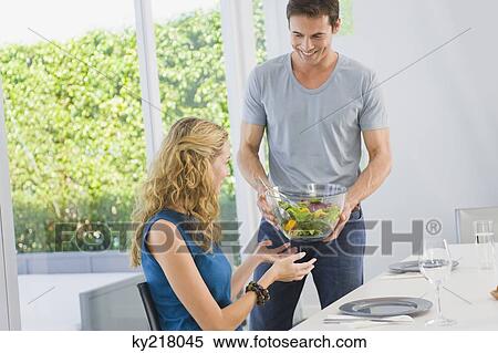 Man giving a bowl of salad to his wife View Large Photo Image Stock Photography - Man giving a bowl of salad to his wife. Fotosearch