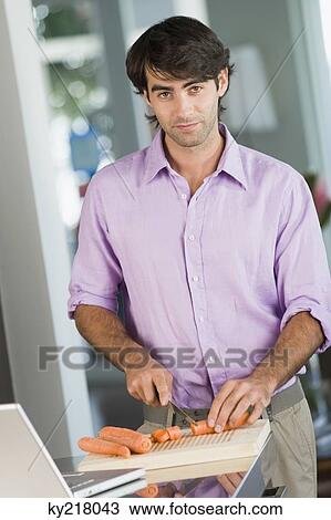 Portrait of a man cooking with the recipe on a laptop View Large Photo Image Stock Image - Portrait of a man cooking with the recipe on a laptop. Fotosearch