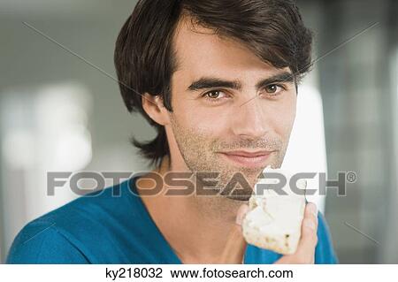 Portrait of a man eating a bread View Large Photo Image Stock Image - Portrait of a man eating a bread. Fotosearch
