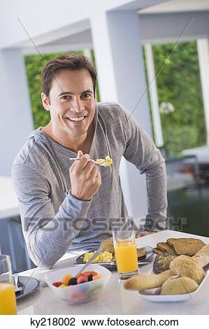Portrait of a man having breakfast and smiling View Large Photo Image Stock Image - Portrait of a man having breakfast and smiling. Fotosearch
