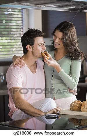 Stock Photo - Woman feeding breakfast to a man. Fotosearch