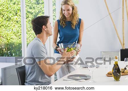 Woman giving a bowl of salad to her husband View Large Photo Image Stock Photograph - Woman giving a bowl of salad to her husband. Fotosearch