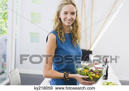 Woman holding a bowl of salad and smiling View Large Photo Image Stock Photo - Woman holding a bowl of salad and smiling. Fotosearch