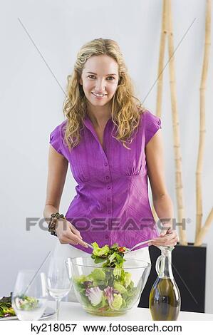Stock Photo - Woman mixing salad in a bowl. Fotosearch