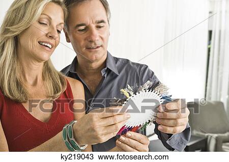 Stock Image - Couple choosing color from a color swatch. Fotosearch