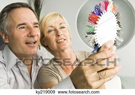 Couple choosing color from a color swatch View Large Photo Image Stock Photo - Couple choosing color from a color swatch. Fotosearch