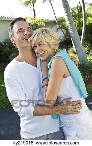 Couple embracing each other and smiling View Large Photo Image Stock Photograph - Couple embracing each other and smiling. Fotosearch