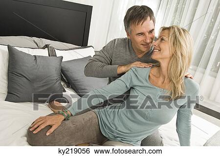 Stock Photograph - Couple romancing in a bedroom. Fotosearch