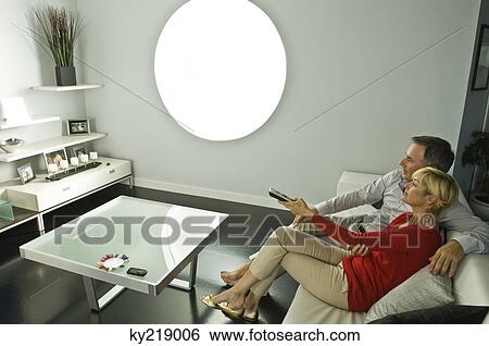 Stock Photograph - Couple watching television on a couch. Fotosearch