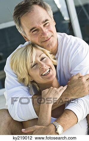 Stock Image - Man embracing a woman from behind. Fotosearch