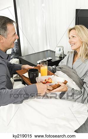 Man giving refreshment to his ill wife View Large Photo Image Stock Photography - Man giving refreshment to his ill wife. Fotosearch
