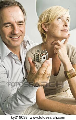 Man looking at a model home with her wife thinking beside him View Large Photo Image Stock Photo - Man looking at a model home with her wife thinking beside him. Fotosearch