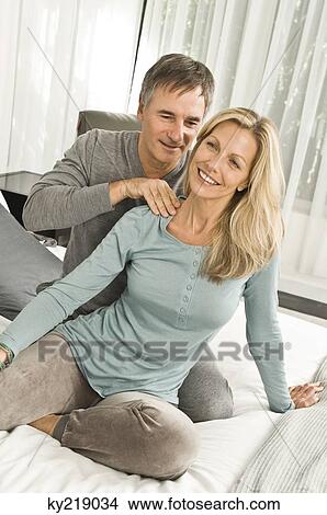 Man massaging a woman's shoulders in a bedroom View Large Photo Image Picture - Man massaging a woman's shoulders in a bedroom. Fotosearch
