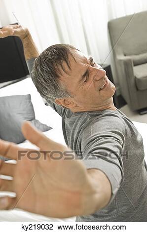 Stock Image - Man stretching in the bed. Fotosearch