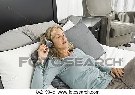 Woman listening to music with headphones View Large Photo Image Stock Photography - Woman listening to music with headphones. Fotosearch