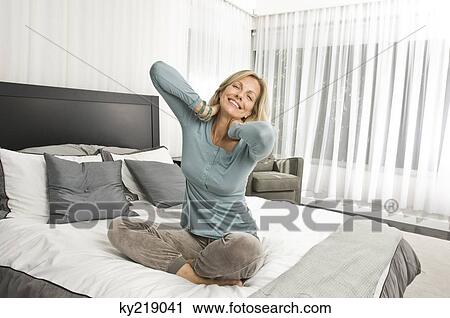 Woman stretching in bed and smiling View Large Photo Image Stock Image - Woman stretching in bed and smiling. Fotosearch