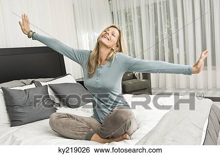 Woman stretching in bed and smiling View Large Photo Image Stock Photograph - Woman stretching in bed and smiling. Fotosearch