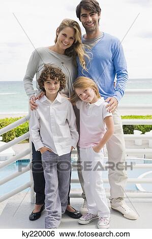 Couple with their children standing by a railing View Large Photo Image Stock Photograph - Couple with their children standing by a railing. Fotosearch