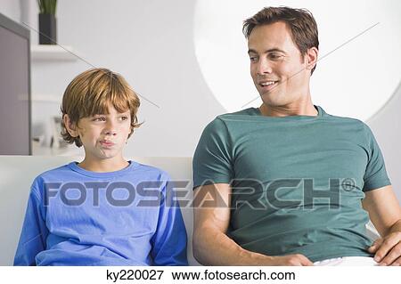 Man sitting with his son View Large Photo Image Stock Photo - Man sitting with his son. Fotosearch