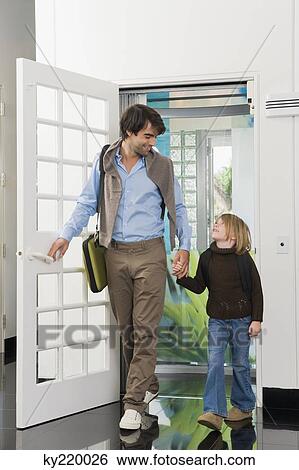 Man with his daughter entering a house View Large Photo Image Stock Photograph - Man with his daughter entering a house. Fotosearch