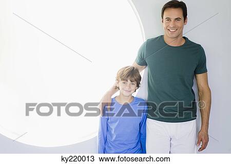 Man with his son standing together View Large Photo Image Stock Image - Man with his son standing together. Fotosearch