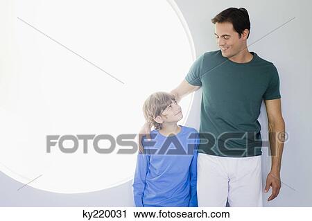 Man with his son standing together View Large Photo Image Stock Image - Man with his son standing together. Fotosearch
