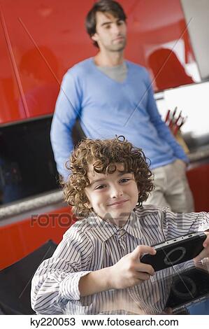 Portrait of a boy holding a video game View Large Photo Image Stock Image - Portrait of a boy holding a video game. Fotosearch