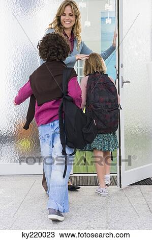 Woman welcoming her children at the door View Large Photo Image Stock Image - Woman welcoming her children at the door. Fotosearch
