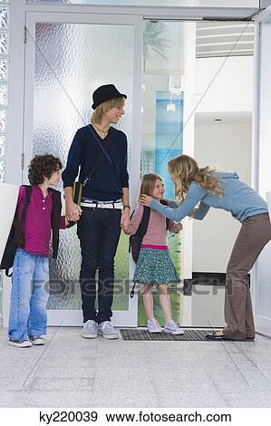 Woman with her children and a nanny at the entrance of a house View Large Photo Image Stock Photo - Woman with her children and a nanny at the entrance of a house. Fotosearch
