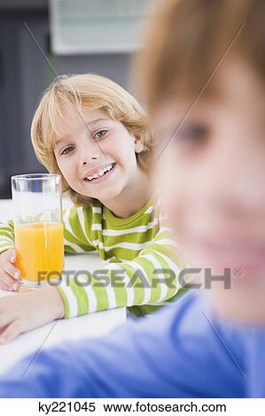 Boy holding a glass of juice View Large Photo Image Stock Photography - Boy holding a glass of juice. Fotosearch