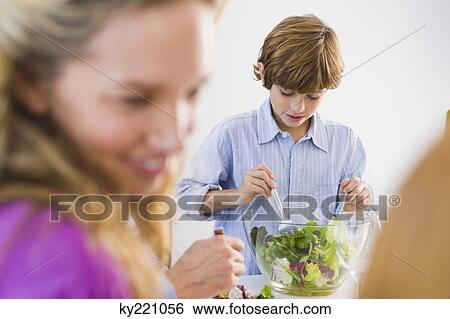 Boy mixing salad in a bowl View Large Photo Image Stock Photograph - Boy mixing salad in a bowl. Fotosearch