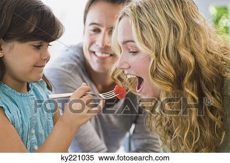 Girl feeding fruit salad to her mother View Large Photo Image Stock Photography - Girl feeding fruit salad to her mother. Fotosearch