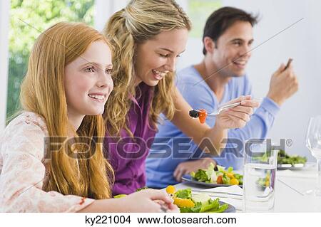 Girl with her parents at the dining table View Large Photo Image Picture - Girl with her parents at the dining table. Fotosearch