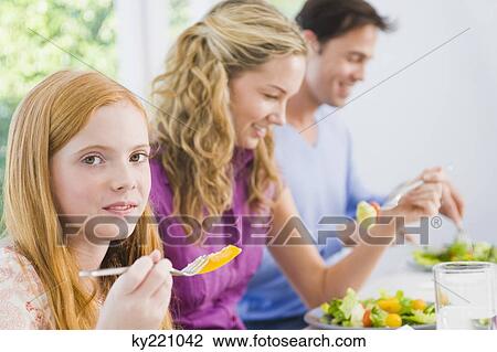 Girl with her parents at the dining table View Large Photo Image Stock Image - Girl with her parents at the dining table. Fotosearch